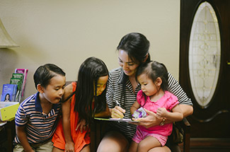 Mother reading book to kids